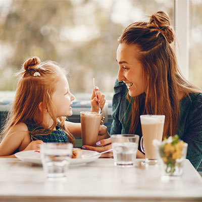Mother and daughter having milkshakes at a cafe